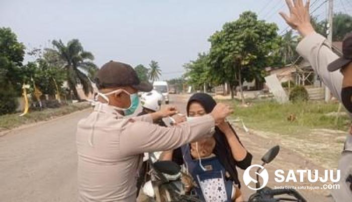 Peduli Dampak Kabut Asap Karhutla, Polsek Langgam Bagikan Masker kepada Warga